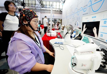 A staff member demonstrates a brain-computer interface for post-stroke rehabilitation at the World R...