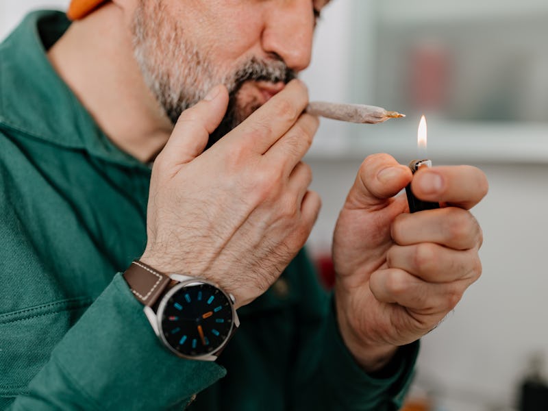 A close-up of a mature Caucasian man taking a hit of medical marijuana.