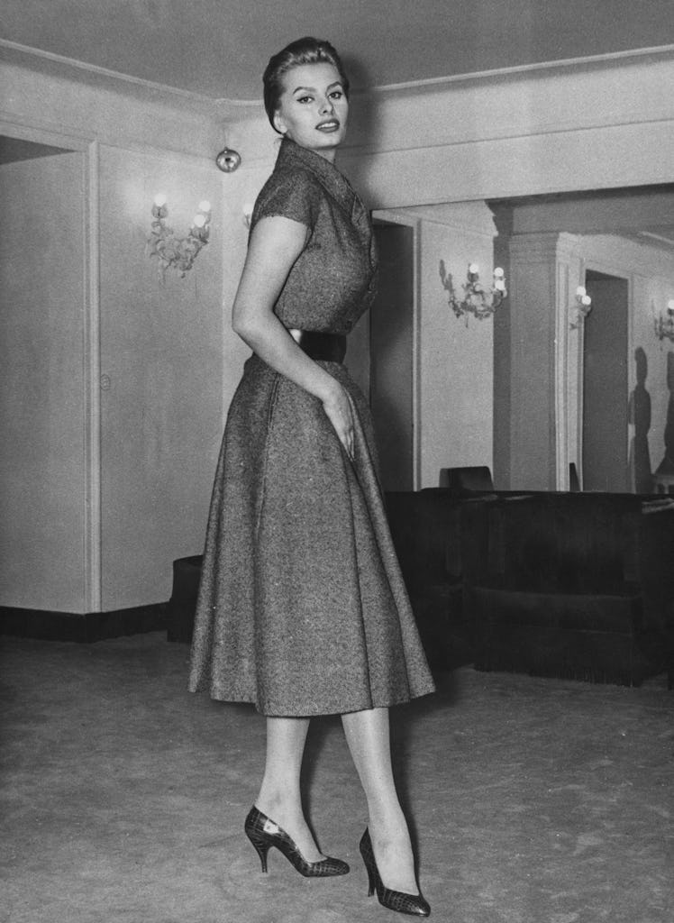 Sophia Loren tries on a Christian Dior 'New Line' dress made by Battilocchi of Rome, in a store in R...