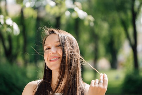Great to be in love: Alluring middle-aged Caucasian lady with long brown hair looking at camera with...