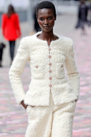 A model walks the runway in a white tweed suit during the Chanel Haute Couture Fall/Winter 2023/2024...