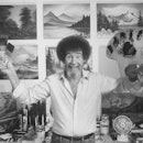 TV painting instructor/artist Bob Ross jubiantly holding up paint pallette & brushes as he stands in...