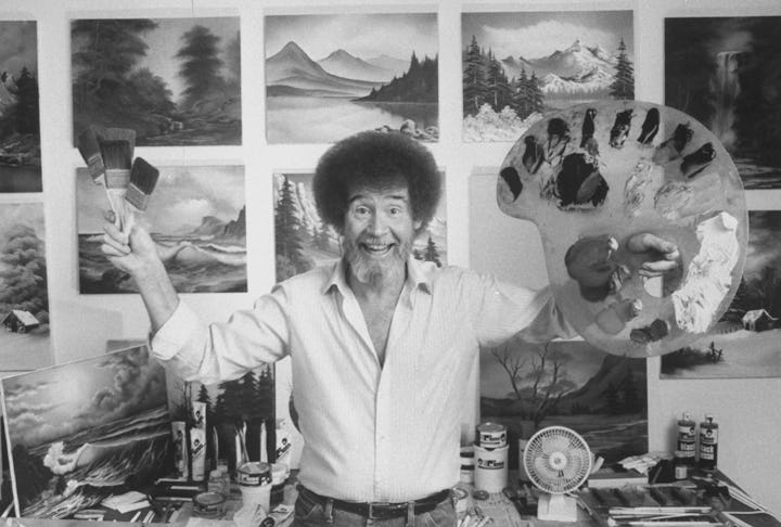 TV painting instructor/artist Bob Ross jubiantly holding up paint pallette & brushes as he stands in...
