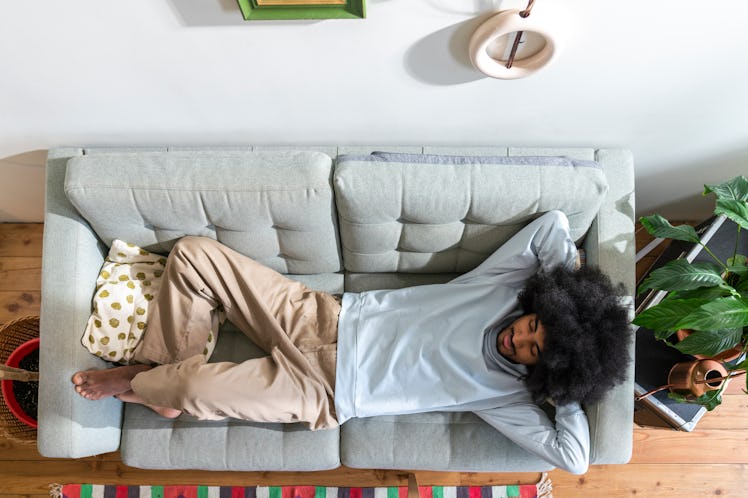 A man takes a nap on a couch.