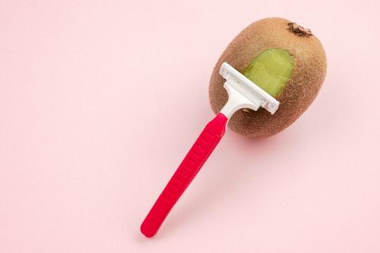 Kiwi fruit and razor on pink background concept art for grooming tips