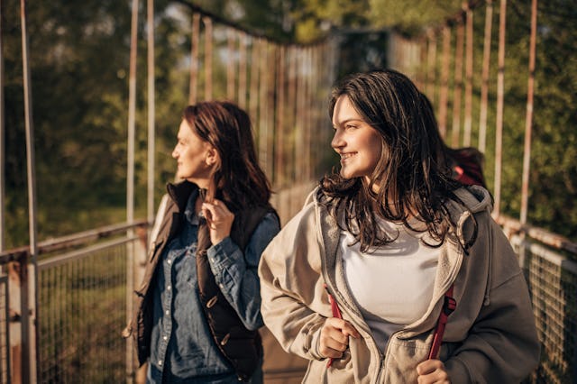 Mother and daughter on a small bridge in nature together.
