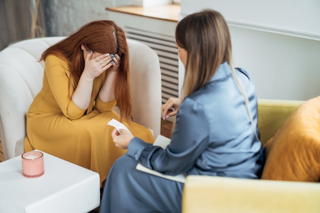 Two women in armchairs are sitting and talking. 