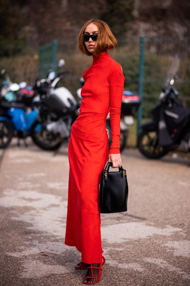 Nadia Lee Cohen wears a red long dress, red sandals and black Ferragamo bag, outside Salvatore Ferra...