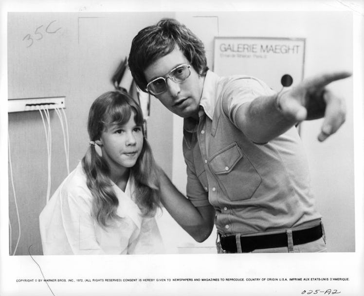 Linda Blair listens to instructions being given to her by director William Friedkin in a scene from ...