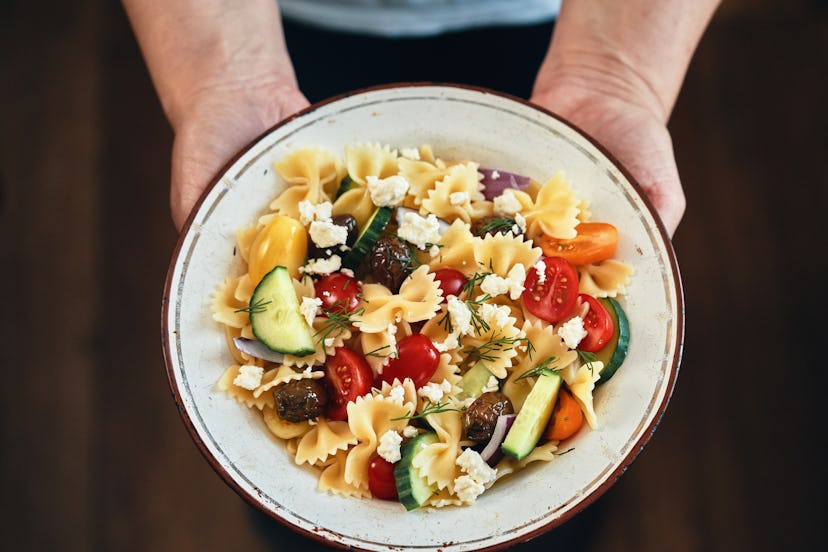 The base of the salad consists of farfalle pasta in greek style. The Greek Salad includes traditiona...