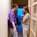 Close-up of a young couple arguing at home in a hallway.