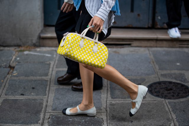 PARIS, FRANCE - OCTOBER 02: Guests seen wearing yellow checkered bag louis vuitton outside Vivienne...