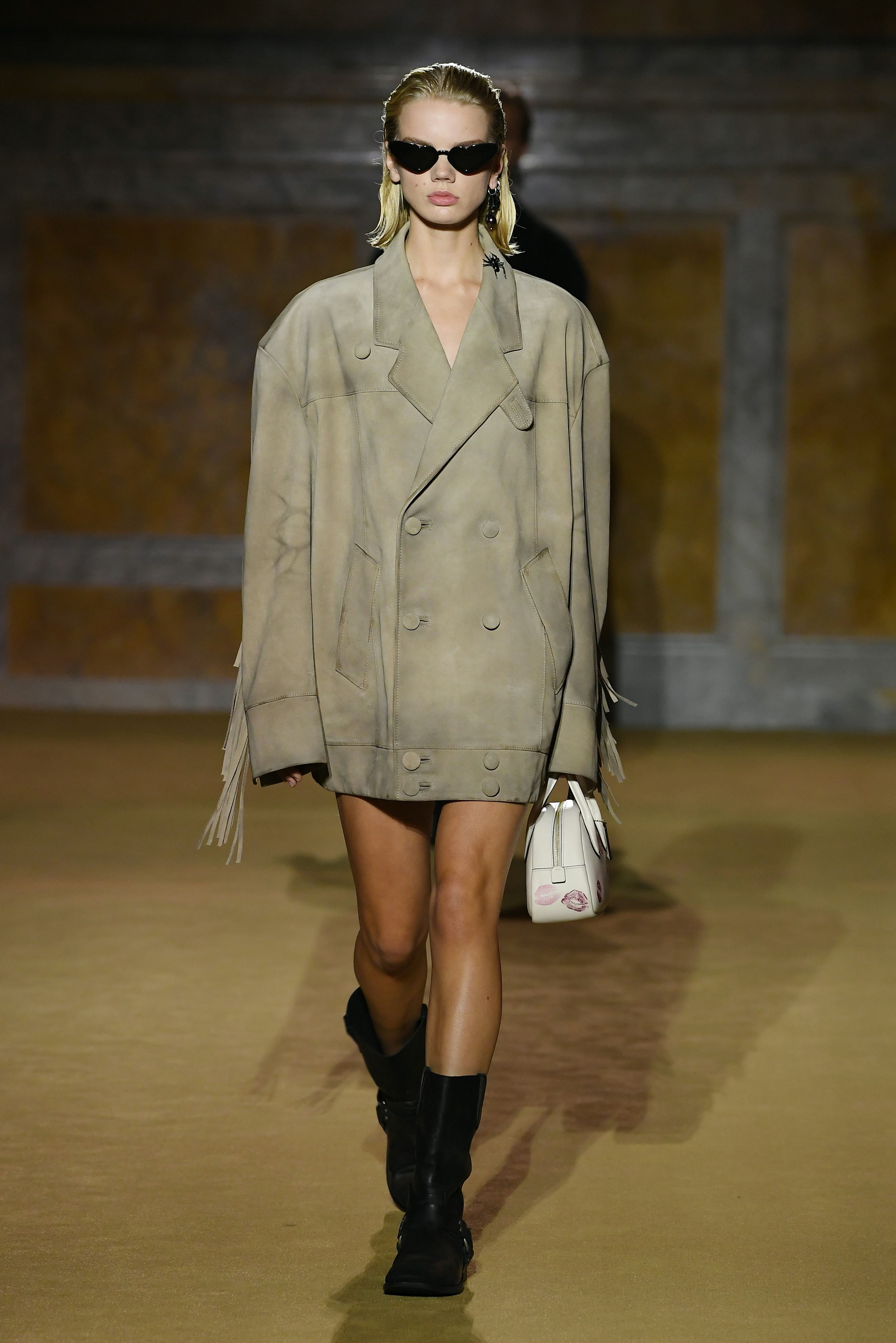 A model wearing a boxy suede jacket on the COACH Spring 2024 runway.
