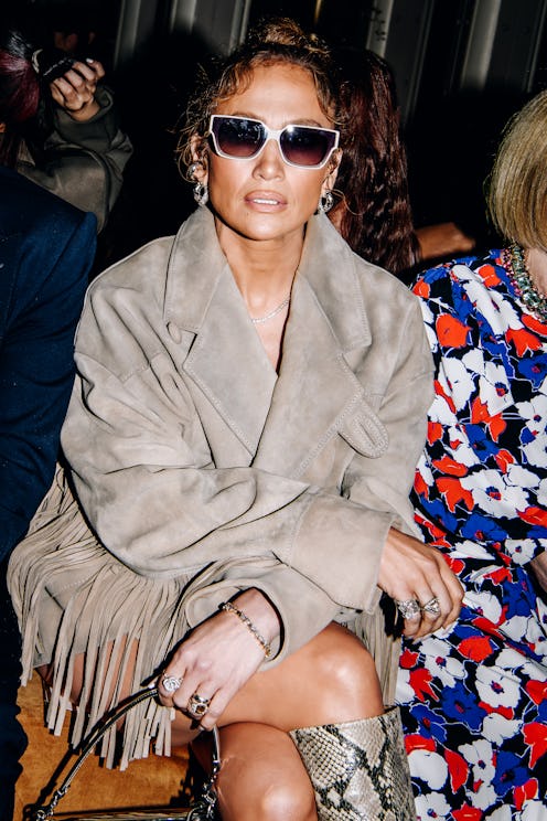 Jennifer Lopez wears a suede jacket, snakeskin boots, and a Coach Tabby bag at the COACH Spring 2024...