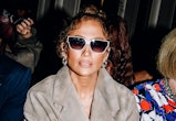 Jennifer Lopez wears a suede jacket, snakeskin boots, and a Coach Tabby bag at the COACH Spring 2024...