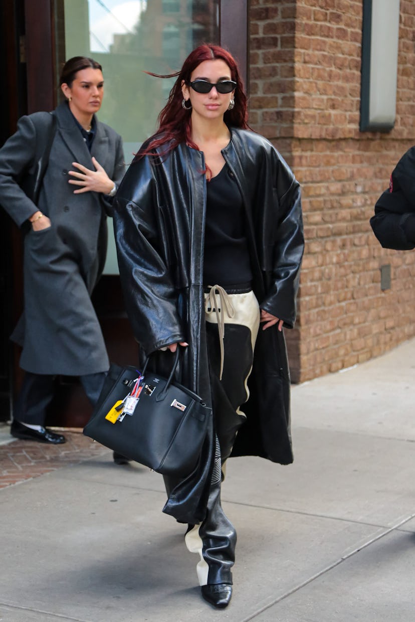 Dua Lipa wears a Hermès Birkin with a leather jacket and matching pants