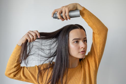 Woman applying hair spray