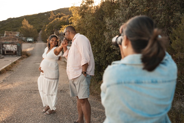 Photographer taking photo of pregnant couple, a maternity photoshoot would be a great valentines day...