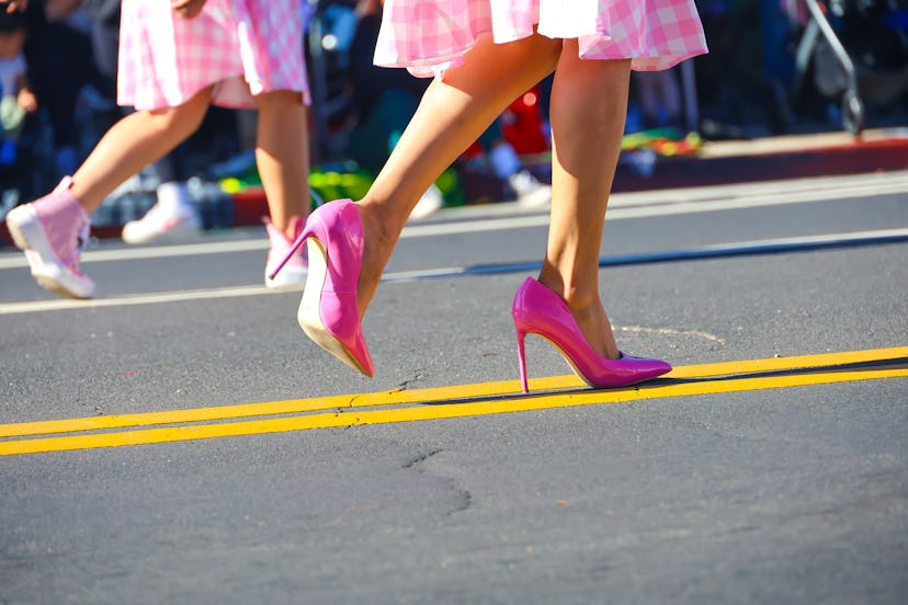 A woman in pink spike heels walks along a parade route in downtown Oxnard, California.