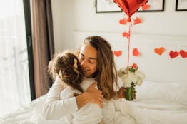 Ð¡ute daughter congratulates her mother on Mother's Day or Valentine's Day and gives red balloon in ...