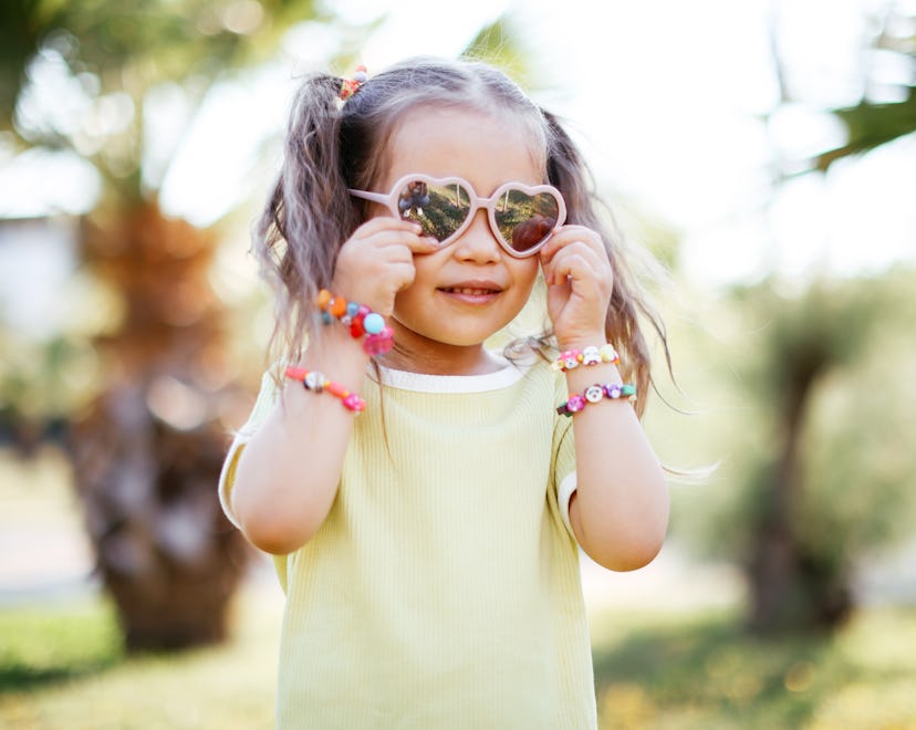She's alone in a peaceful natural setting, with a forest in the background.