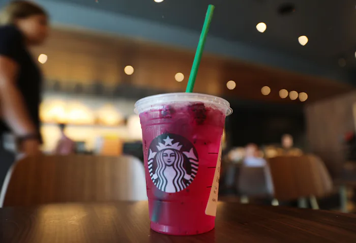A purple starbucks refresher on a table, in a story answering the question, can you drink starbucks ...