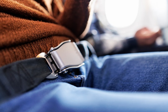 Closeup of the teenager travelling by plane with fastened seat belt 
Shot with Canon R5