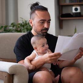 Young father working at home office with baby girl
