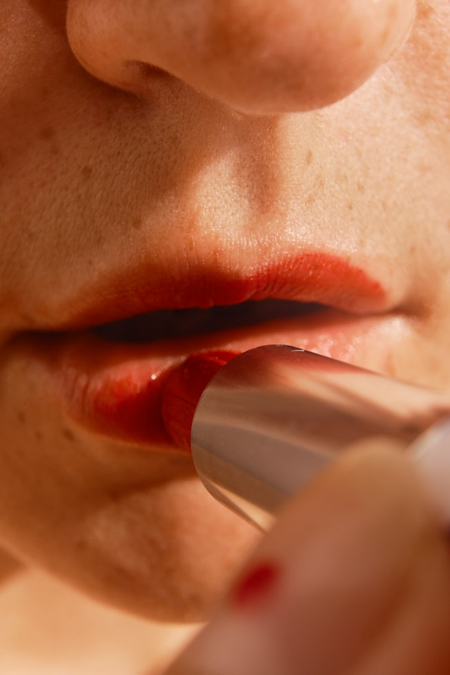 fontal view of an open mouth of a woman using red lipstick