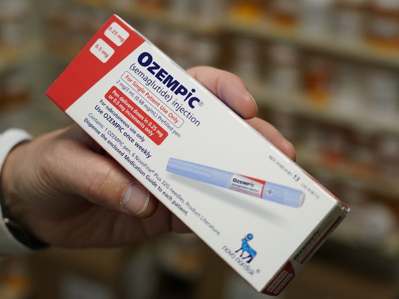 A pharmacist holds a box of Novo Nordisk A/S Ozempic brand semaglutide medication arranged at a phar...