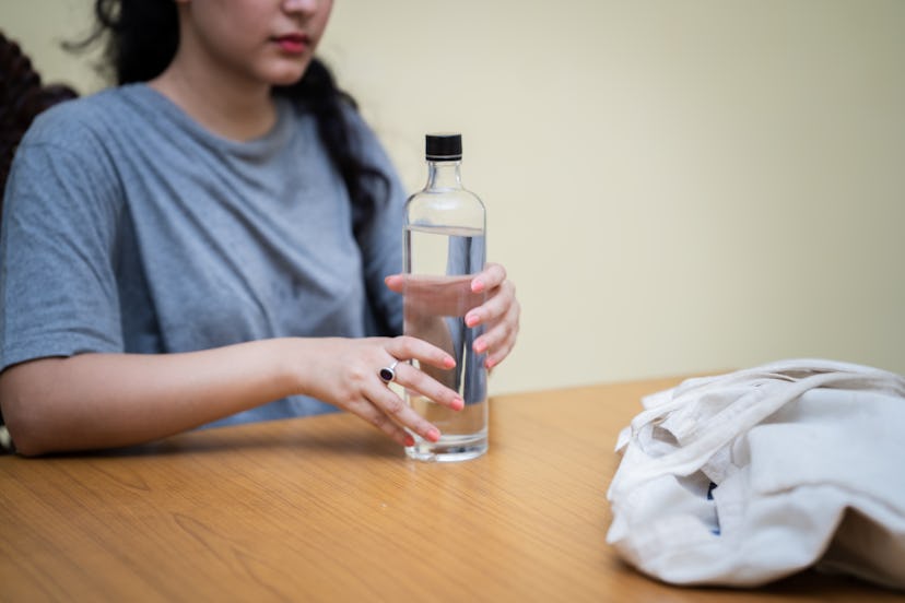Young woman using a reusable water bottle.