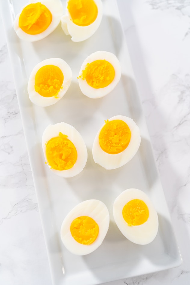 Sliced hard-boiled eggs on a white serving plate.