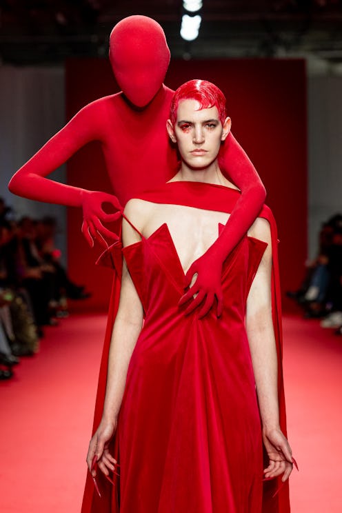 A model walks the runway during the Robert Wun Haute Couture Spring/Summer 2024 show with a red mann...