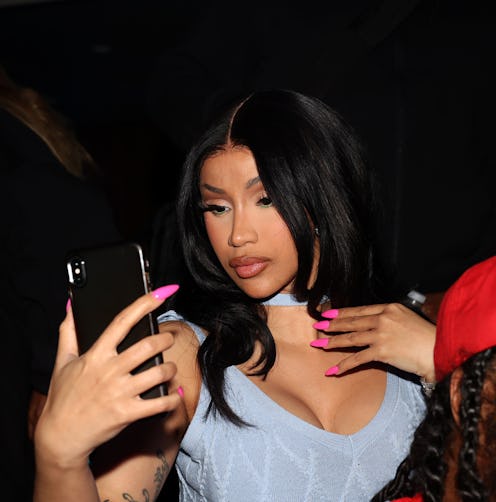 Cardi B rang in the New Year with a fresh makeup look, thin eyebrows, and blue eye contacts.