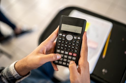 Close-up of a student using calculator in the classroom at university