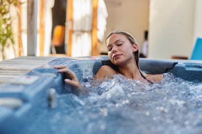 Young woman spending a summer day in hot tub.