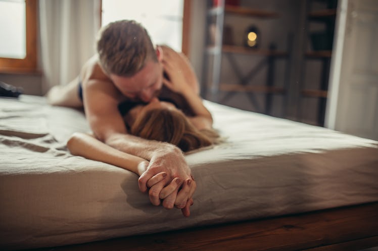 Man and woman, young heterosexual couple in bed, lying in bed and hugging.