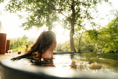 Photo of a young woman soaking in a garden tub.