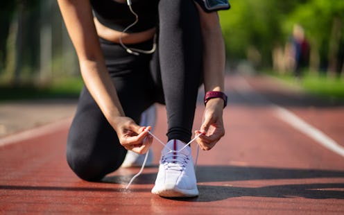 Running shoes. Woman tying shoe laces. Closeup of female sport fitness runner getting ready for jogg...