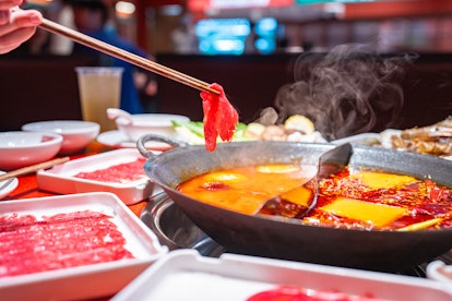 On the table is a hot pot with two flavours. One is Mala hot pot at a restaurant.