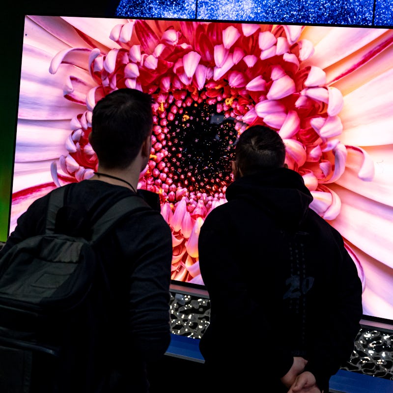 04 September 2022, Berlin: Visitors look at televisions at the stand of the LG brand at the electron...