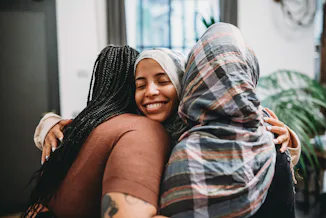 a group of friends embrace as they consider how the January 2024 Full Wolf Moon will affect 4 zodiac...
