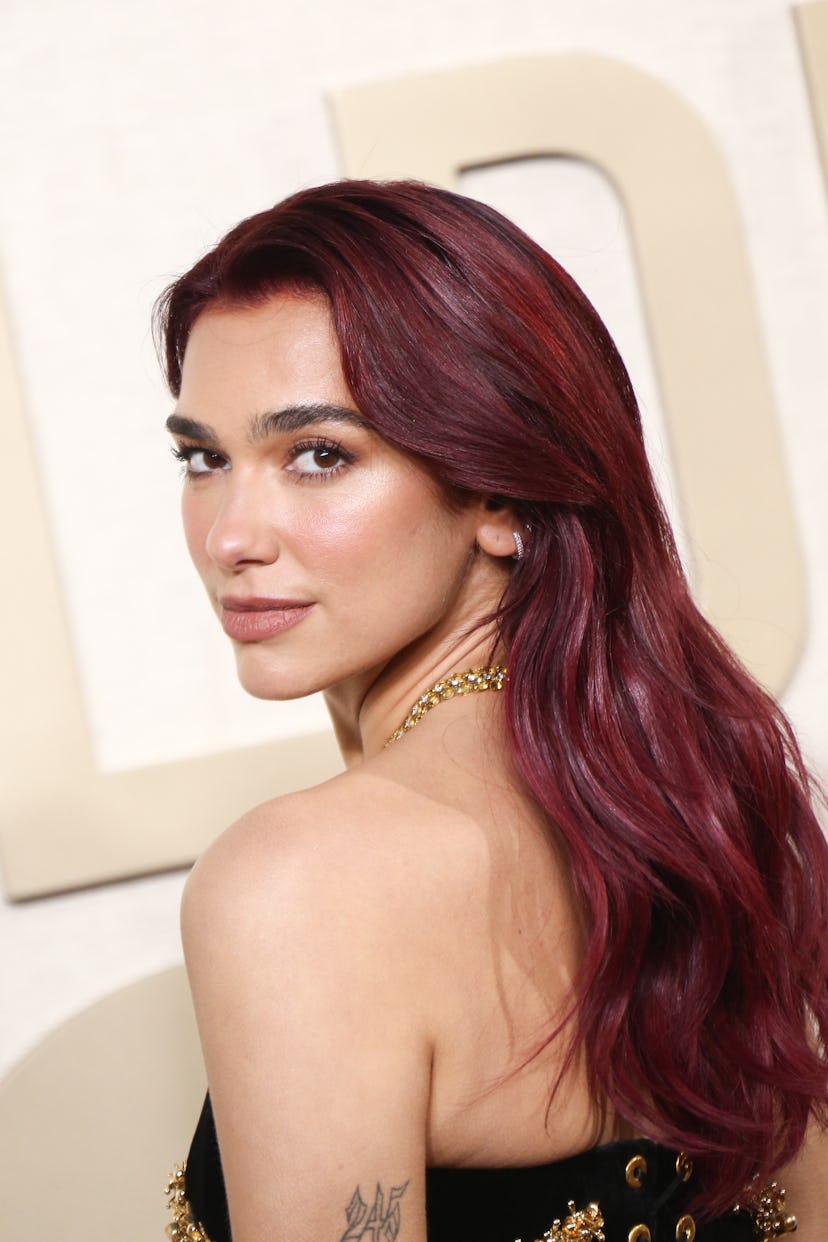 Dua Lipa’s soft beat makeup and cherry coke hair at the 2024 Golden Globe Awards.