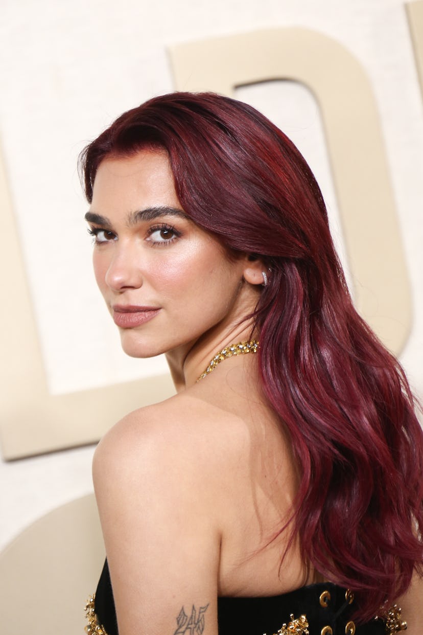 Dua Lipa's soft beat makeup and cherry coke hair at the 2024 Golden Globe Awards.
