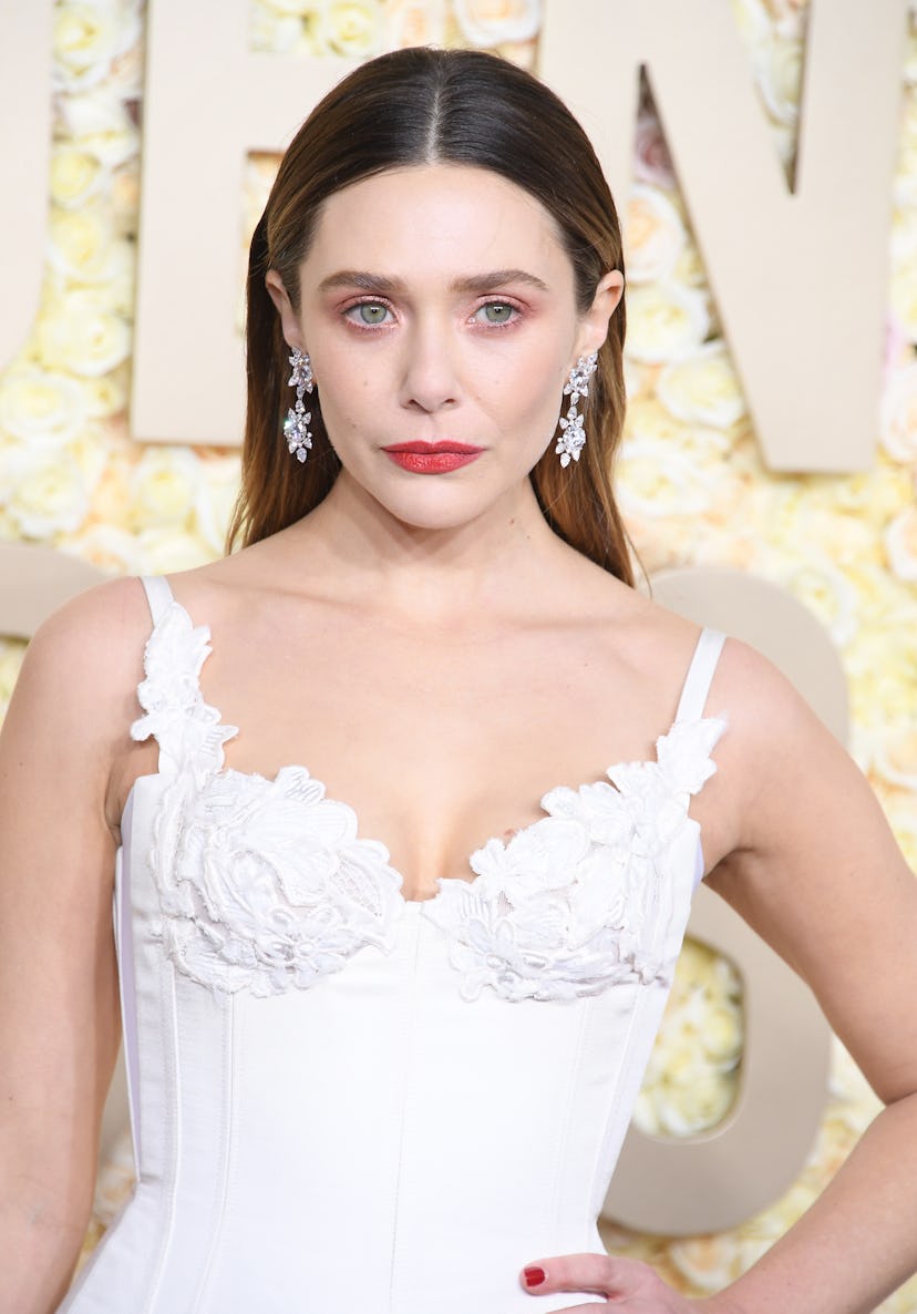 Elizabeth Olsen opted for coral-red makeup pigments on her eyes and lips at the 2024 Golden Globe Aw...