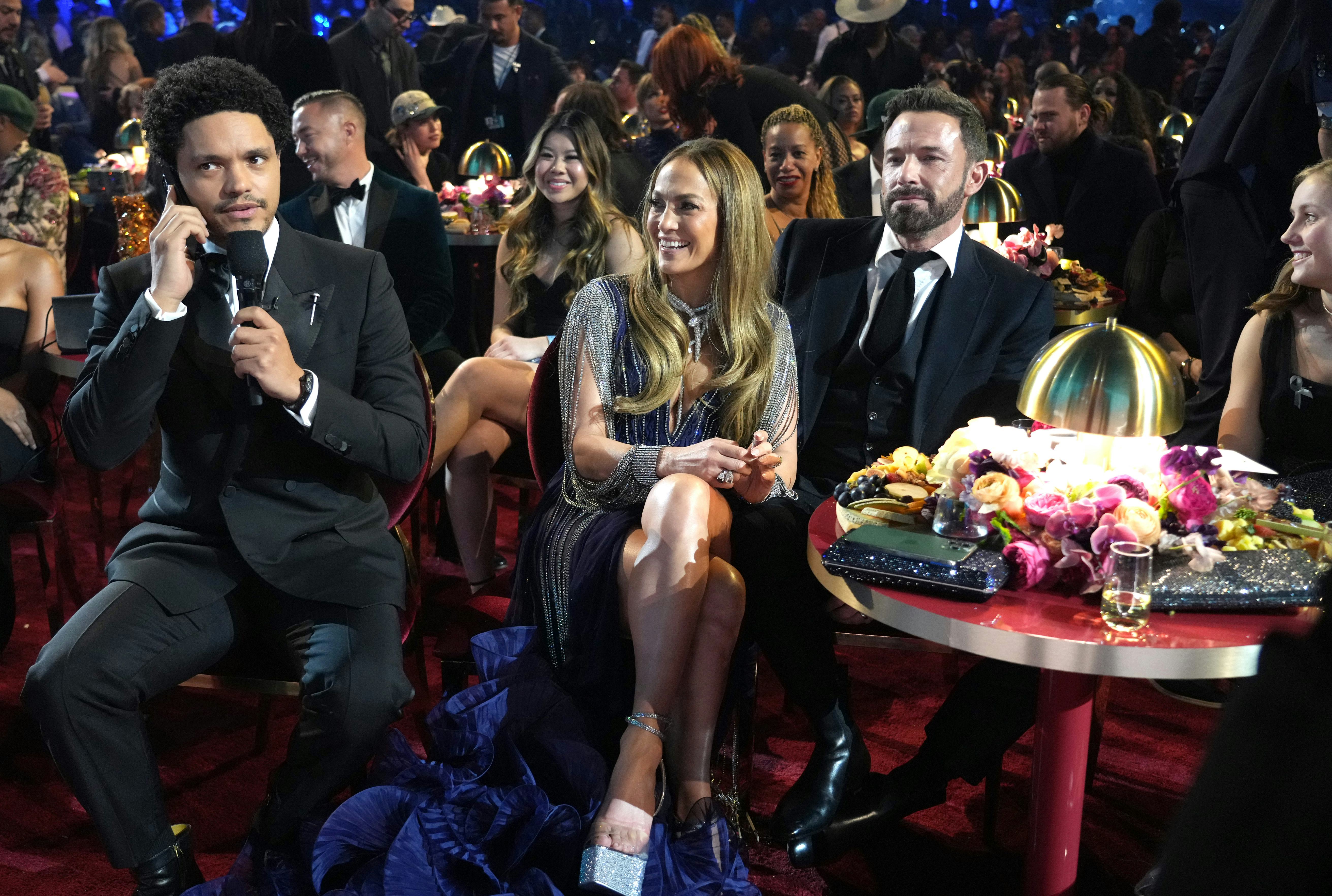 Trevor Noah and Jennifer Lopez with Ben Affleck looking miserable at the Grammys