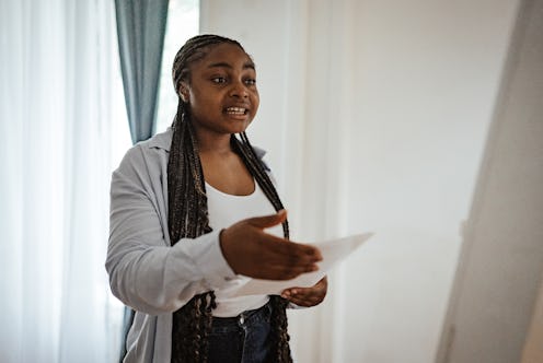 An expressive woman practicing her speech, using hand movements to emphasize points, highlighting he...