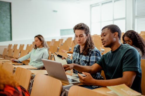 Diverse Multiethnic Group of Female and Male Students Sitting in College Room, Collaborating on Scho...