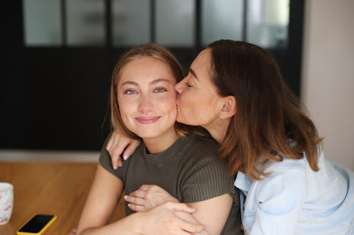 A mom and daughter posing together, they hugging each other