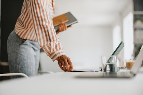 Close-up of a businessperson organizing files in an office setting, readying for a meeting or presen...